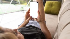 ragazza con smartphone sul divano